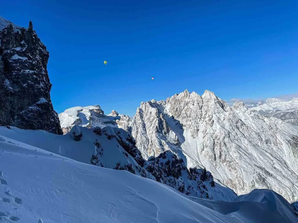 Heissluftballons am blauen Himmel in der Winterlandschaft Südtirols