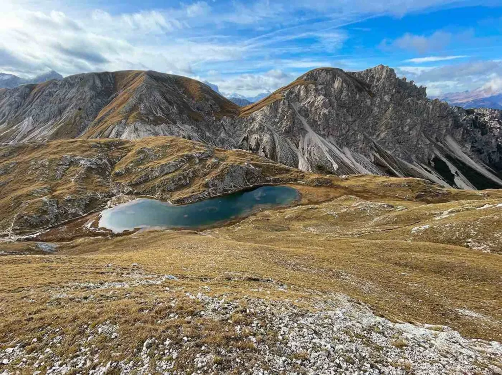 Blaugrüner Bergsee am Piz da Peres, umgeben von einer prächtigen Bergefront